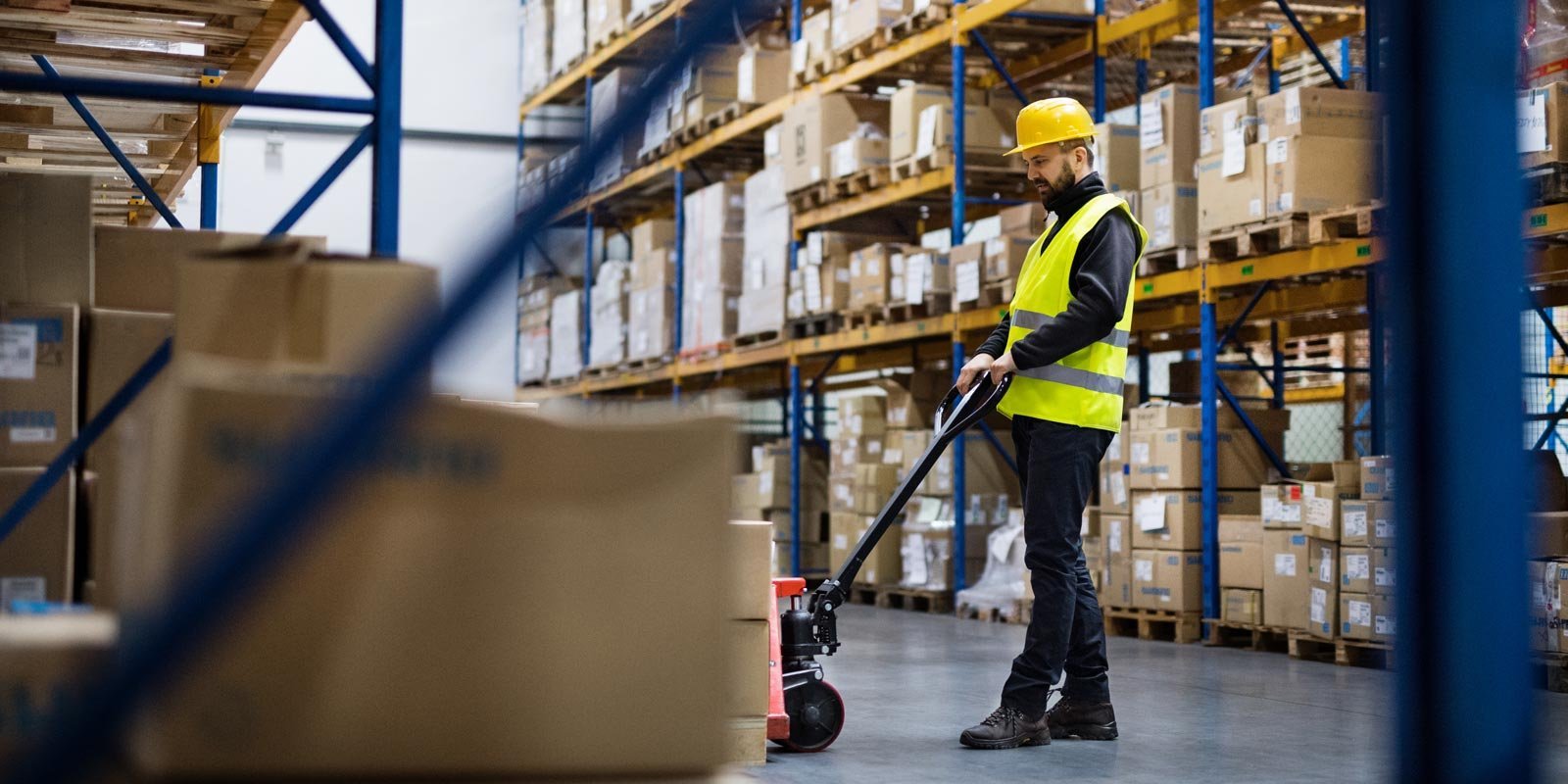 Eine Lagerhalle mit einem Lagerist der ein Hubwagen bedient