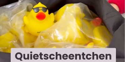 Eine Gruppe von gelben Quietscheentchen, die in einer durchsichtigen Tüte verpackt sind, mit einer coolen Sonnenbrille auf einem Entchen.